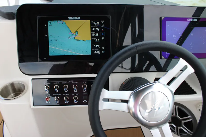 Slide: The Image of The image shows the dashboard of a Sea Ray SDX 250 Surf with modern navigation systems. - 26