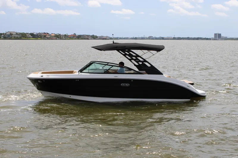 Slide: The Image of A 2026 Sea Ray SDX 250 Surf cruising on calm waters with a driver on board. - 8