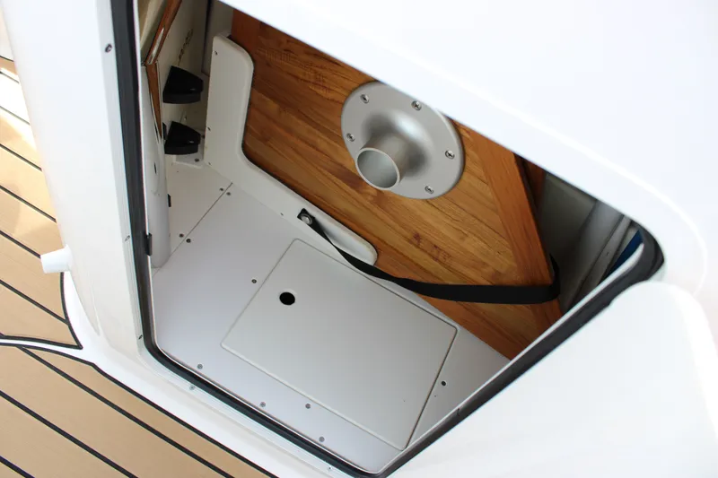 Slide: The Image of A view into a storage compartment with wooden flooring and white walls on a Sea Ray SDX 250 Surf. - 14