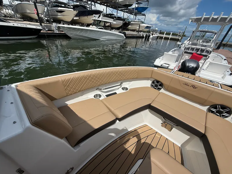 Slide: The Image of The image shows the cockpit of a Sea Ray SDX 230 Outboard with beige upholstery and wood flooring. - 6