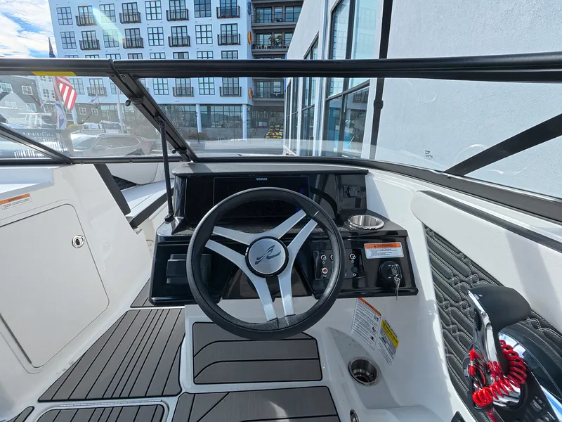 Slide: The Image of The cockpit of a 2027 Sea Ray SPX 210 Outboard with a modern steering wheel and instruments. - 25