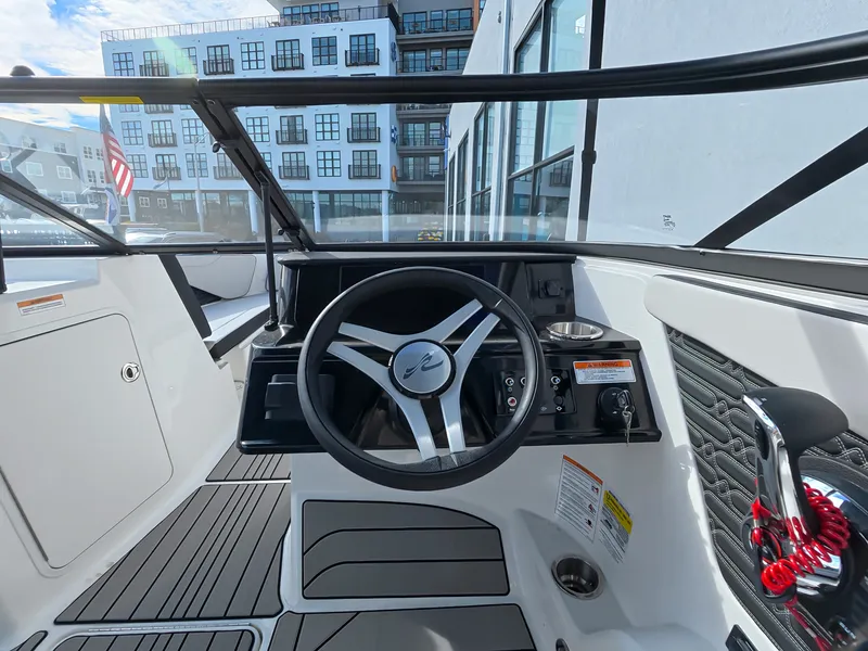 Slide: The Image of The image shows the cockpit of a Sea Ray SPX 210 Outboard with a modern steering wheel and controls. - 26