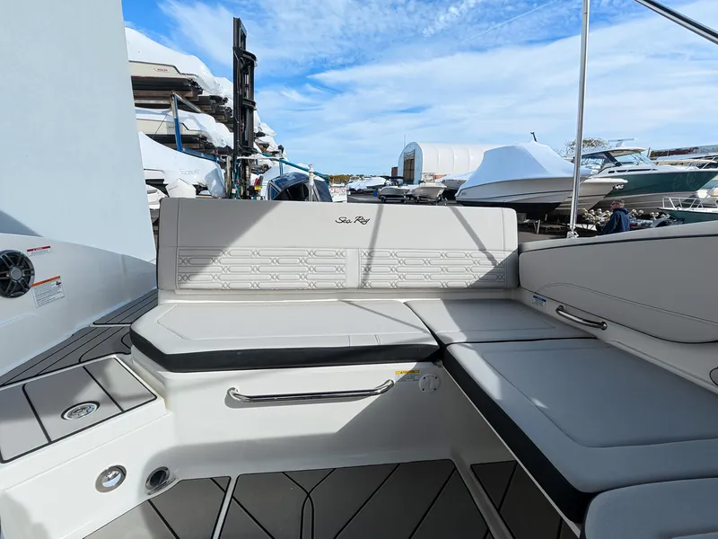 Slide: The Image of The image shows the stern of a Sea Ray SPX 210 Outboard with beige upholstery and storage. - 18