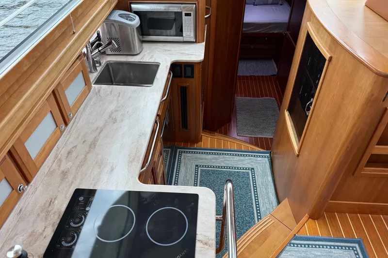 Slide: The Image of 2019 Sabre 45 Salon Express yacht interior with modern kitchen and wooden cabinetry. - 27