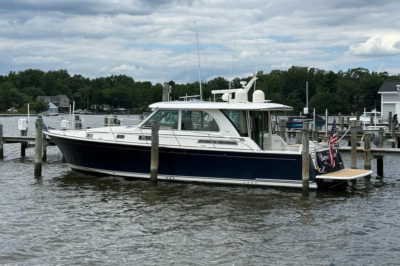 Slide: The Image of 2019 Sabre 45 Salon Express yacht docked at a marina under cloudy skies. - 47
