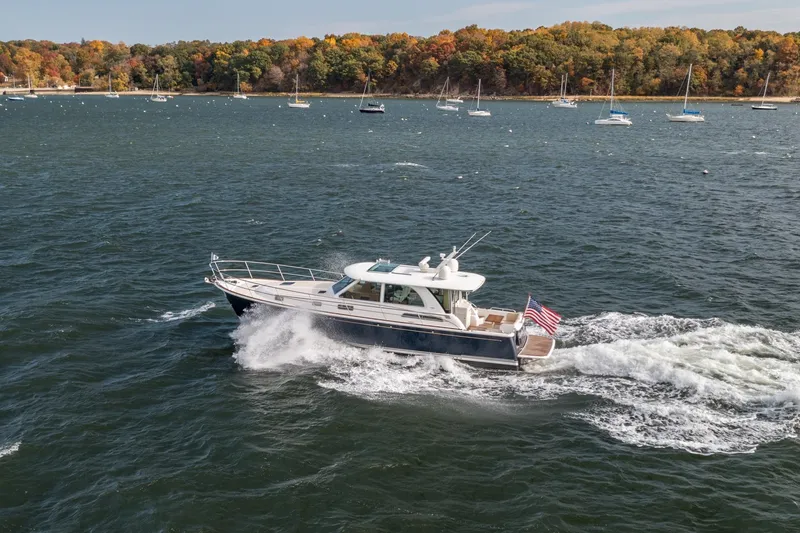 Slide: The Image of 2019 Sabre 45 Salon Express cruising on a scenic lake with autumn foliage. - 49