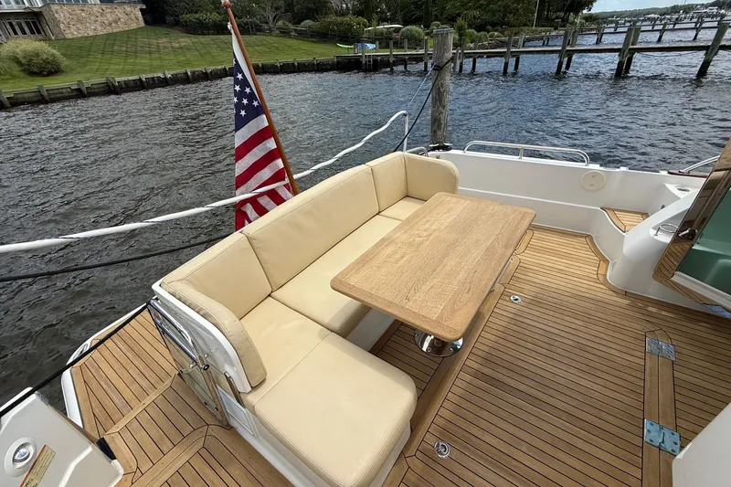Slide: The Image of 2019 Sabre 45 Salon Express yacht deck with seating, table, and American flag. - 9
