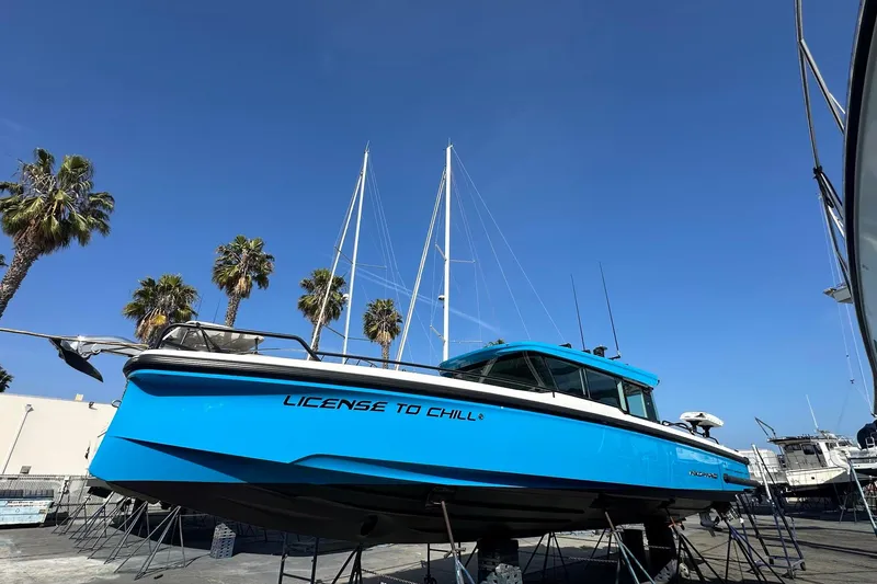 The Image of 2021 Axopar 37 XC Cross Cabin boat on display with palm trees in background. - 0