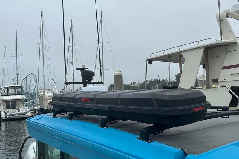 Slide: The Image of 2021 Axopar boat with Yakima cargo box, docked in marina with sailboats. - 10