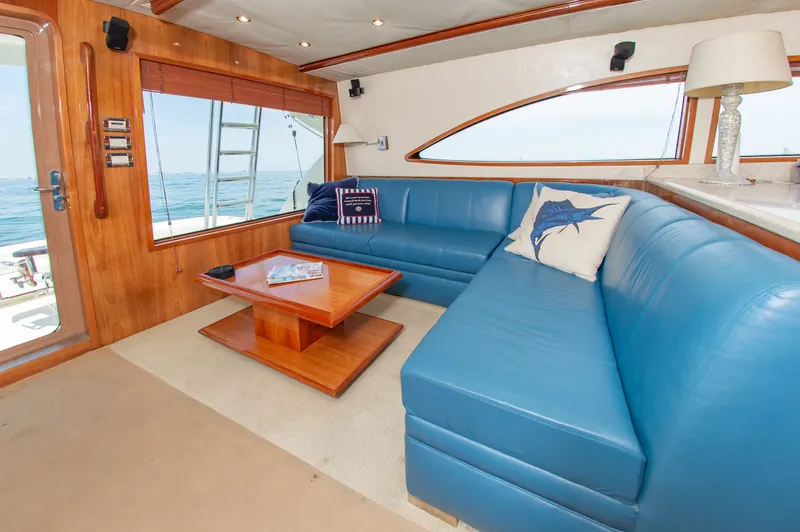 Slide: The Image of Interior of Bertram 510 Convertible yacht, blue leather seating, wooden table, ocean view. - 24