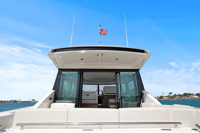 Slide: The Image of 2023 Tiara Yachts C49 Coupe, rear view, open sea, clear sky, luxury design. - 15