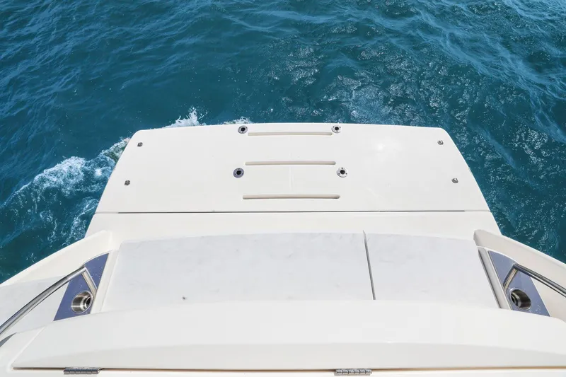 Slide: The Image of 2023 Tiara Yachts C49 Coupe swim platform on blue ocean water. - 16