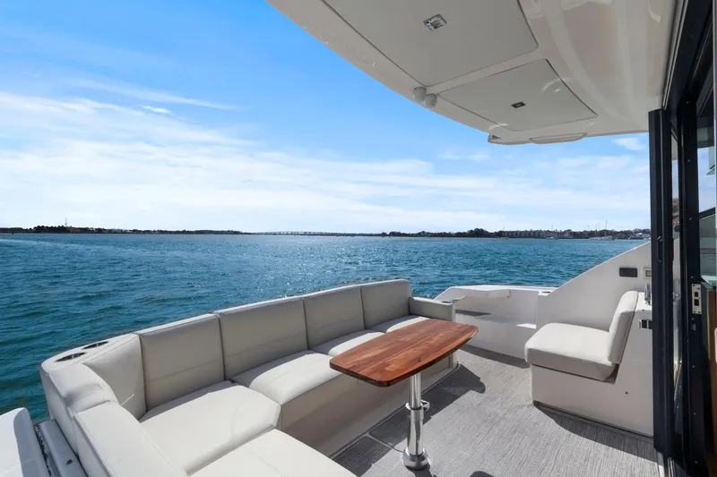 Slide: The Image of 2023 Tiara Yachts C49 Coupe deck with seating and ocean view. - 22