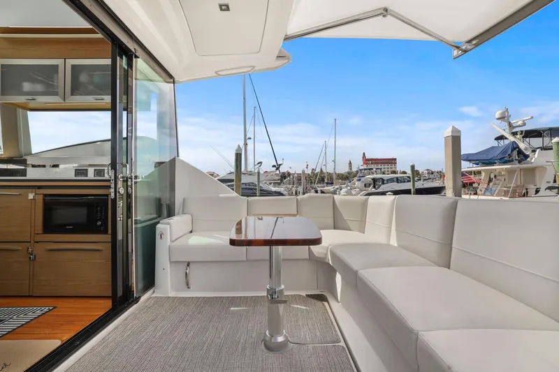 Slide: The Image of 2023 Tiara Yachts C49 Coupe interior with sleek seating and marina view. - 25