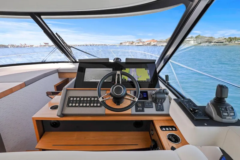 Slide: The Image of 2023 Tiara Yachts C49 Coupe helm with advanced navigation systems and scenic ocean view. - 32