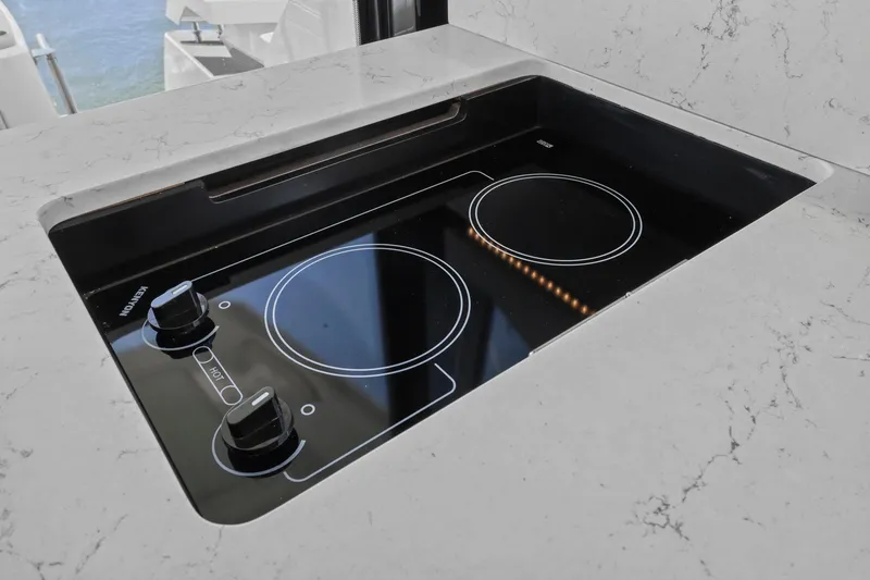 Slide: The Image of Modern stovetop on 2023 Tiara Yachts C49 Coupe, featuring sleek marble countertop. - 47