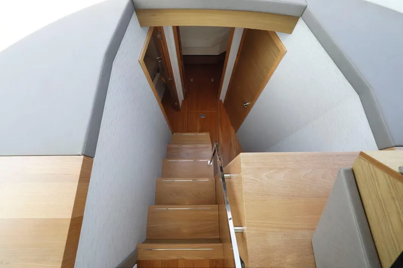 Slide: The Image of Interior staircase of 2023 Tiara Yachts C49 Coupe, featuring sleek wooden design. - 50
