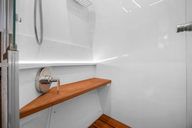 Slide: The Image of 2023 Tiara Yachts C49 Coupe shower with wooden bench and modern fixtures. - 72