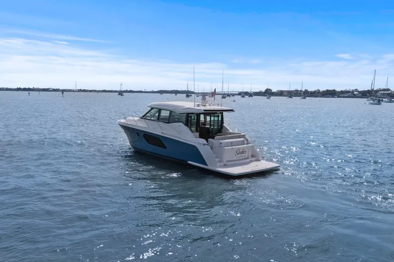 Slide: The Image of 2023 Tiara Yachts C49 Coupe cruising on a sunny day in open waters. - 77