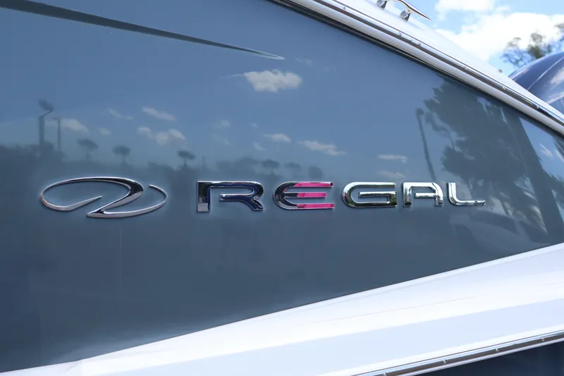 Slide: The Image of 2019 Regal 29 OBX boat logo on sleek gray surface. - 13