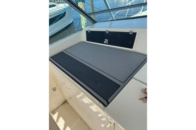 Slide: The Image of 1984 Topaz 37 boat interior with cushioned seating and storage compartment. - 8