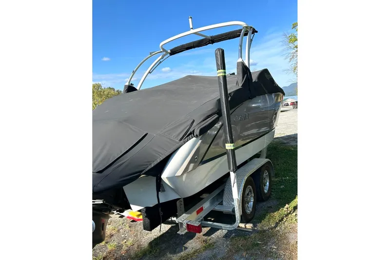 Slide: The Image of 2017 Cobalt R5 boat on trailer, covered, parked outdoors under clear blue sky. - 2