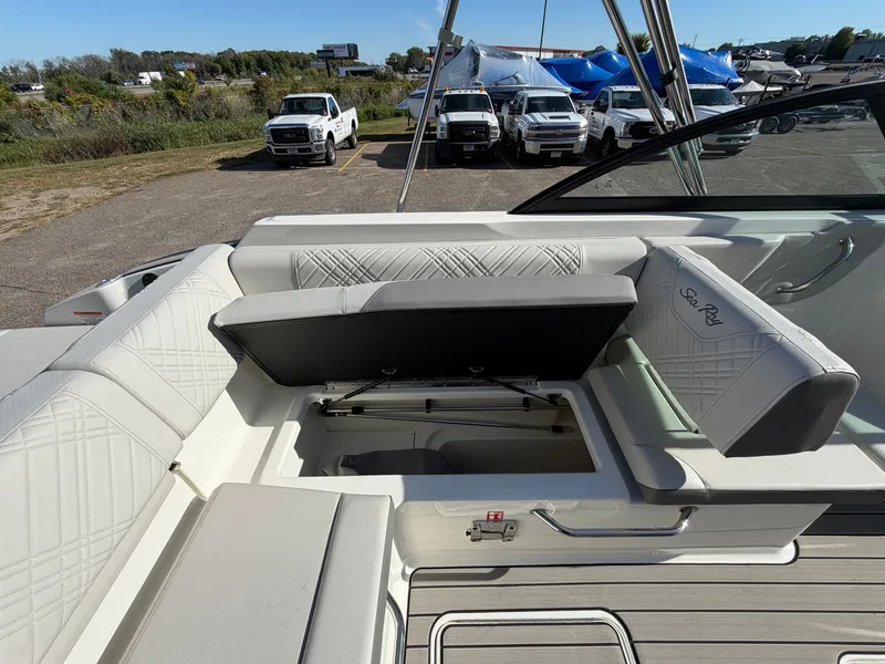 Slide: The Image of The image shows the cockpit of a Sea Ray SDX 230 boat with a seat lifted to reveal storage underneath. - 38
