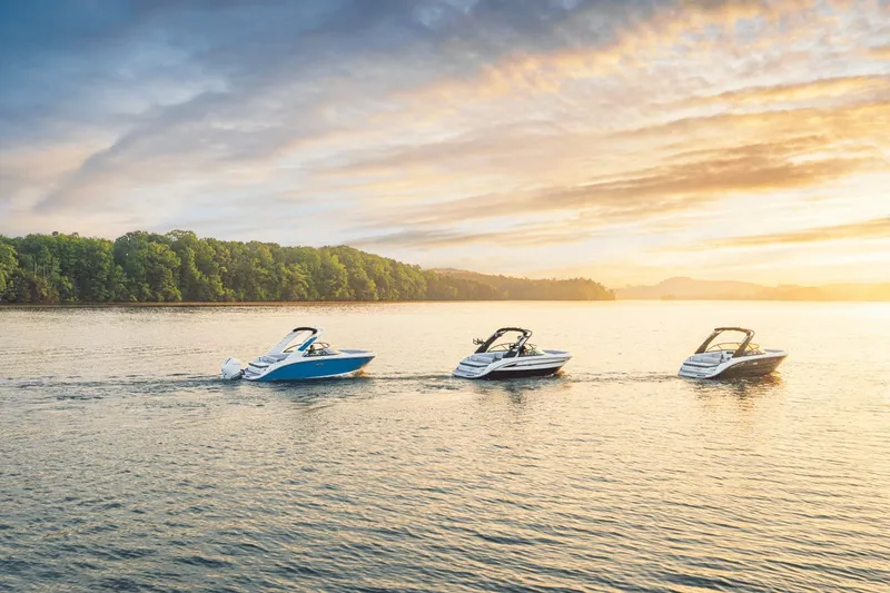 Slide: The Image of Three Sea Ray SDX 230 boats cruising on a calm lake at sunset. - 20