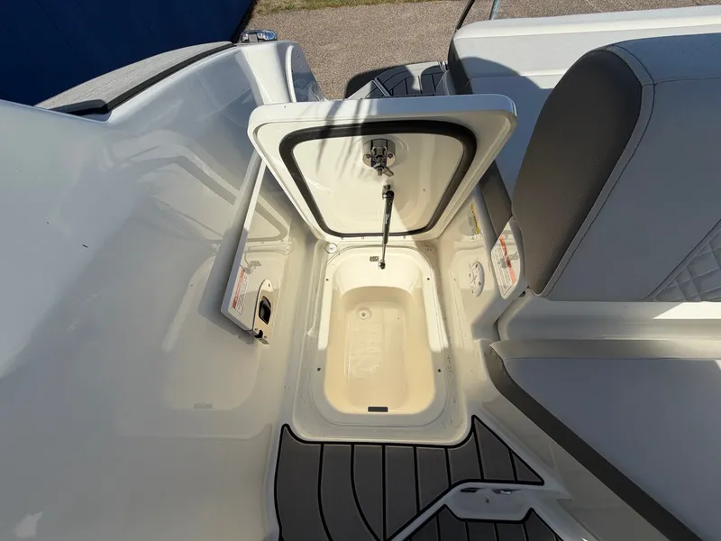 Slide: The Image of An open storage compartment on a 2026 Sea Ray SDX 230 boat, featuring gray flooring. - 44