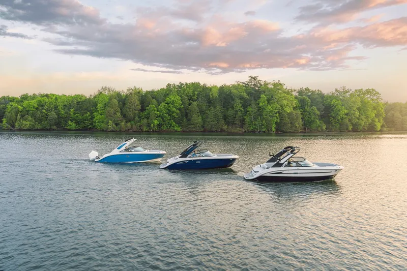 Slide: The Image of Three modern boats on a calm lake with a wooded shoreline at sunset. - 22