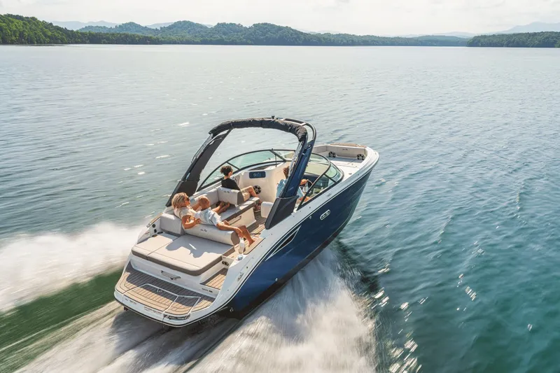Slide: The Image of 2026 Sea Ray SDX 230 on a calm lake with wooded hills in the background. - 15