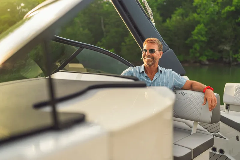 Slide: The Image of A man relaxes on a Sea Ray SDX 230 boat, surrounded by lush greenery. - 5