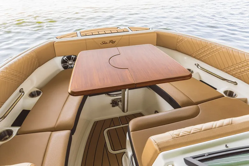 Slide: The Image of The image shows the bow area of a Sea Ray SDX 230 with a wooden table and cushioned seating. - 1