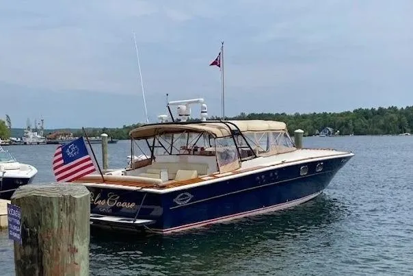 Slide: The Image of Vintage 1979 Magnum 38 Sport boat docked on a serene lake with American flag. - 1