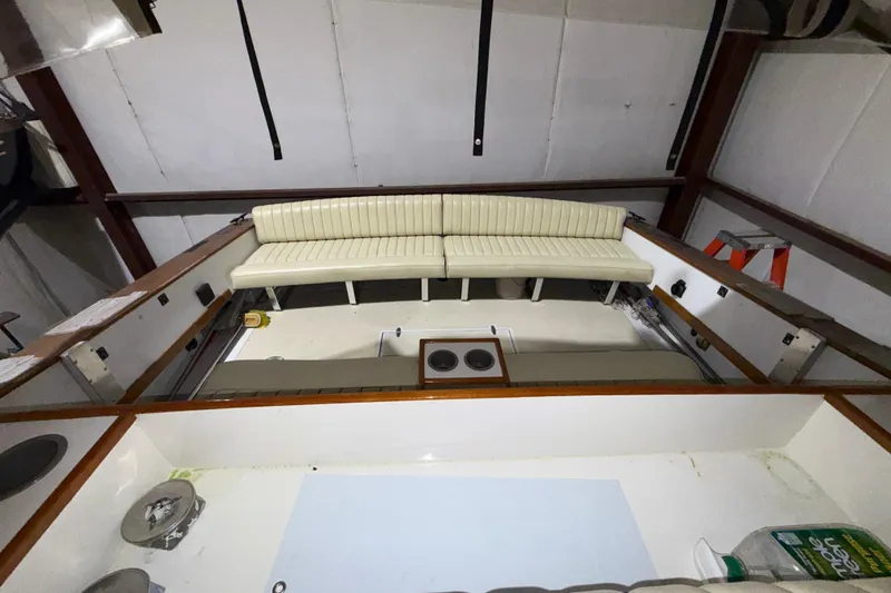 Slide: The Image of 1979 Magnum 38 Sport boat interior with white seating and wooden accents in a garage setting. - 19