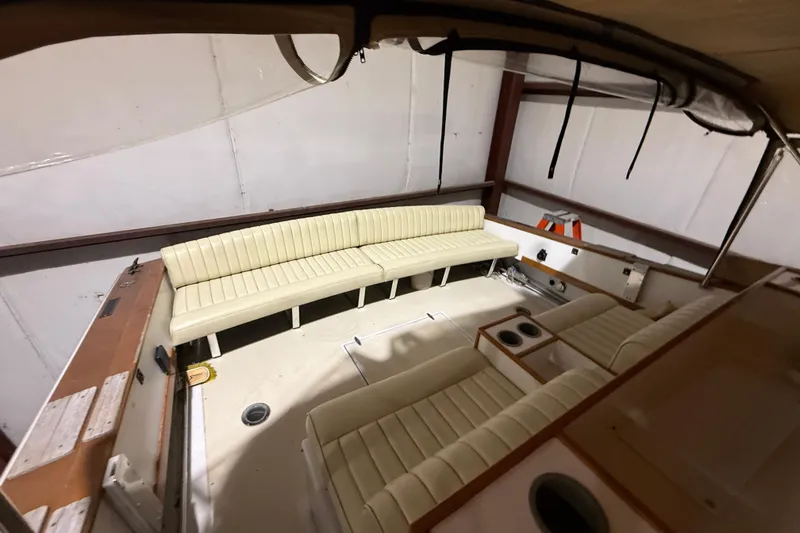 Slide: The Image of 1979 Magnum 38 Sport boat interior with cream seating and cup holders in a storage facility. - 26