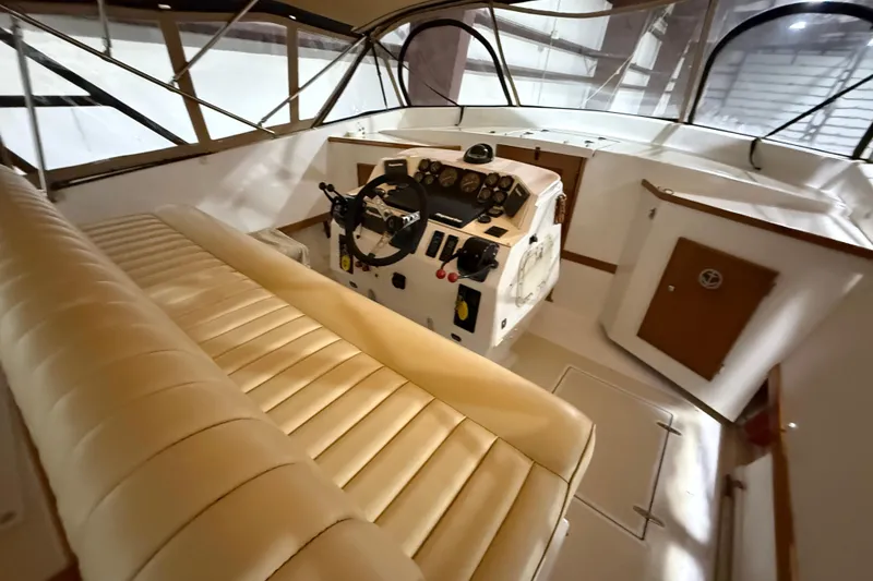 Slide: The Image of Interior of a 1979 Magnum 38 Sport boat with beige seating and control panel. - 28