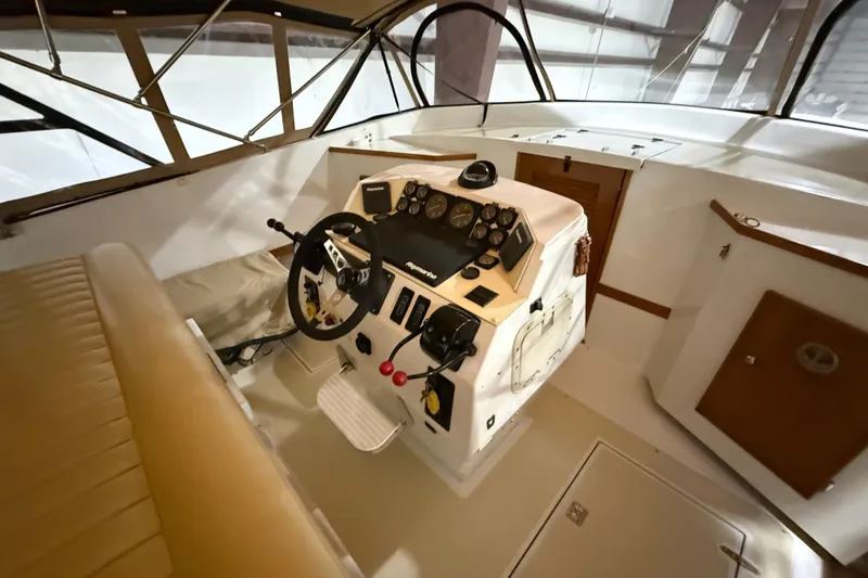 Slide: The Image of Interior cockpit of a 1979 Magnum 38 Sport boat, featuring steering wheel and control panel. - 30
