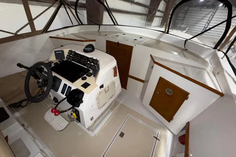 Slide: The Image of Cockpit of a 1979 Magnum 38 Sport boat with steering wheel and control panel. - 38