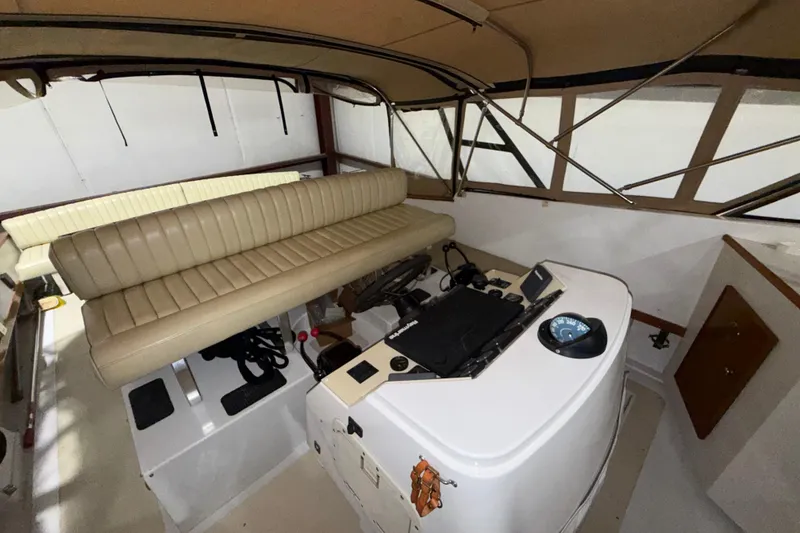 Slide: The Image of Interior of a 1979 Magnum 38 Sport boat with beige seating and control panel. - 39