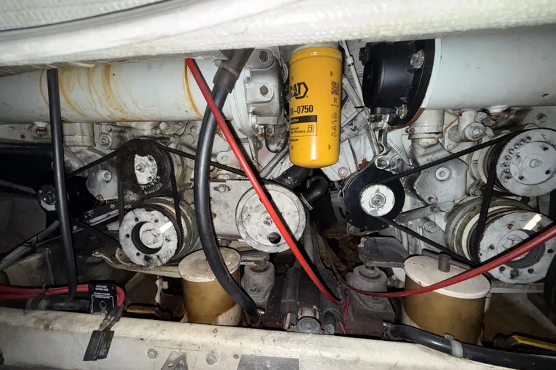 Slide: The Image of Engine compartment of a 1979 Magnum 38 Sport boat, featuring belts and a CAT filter. - 55