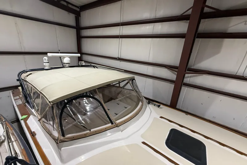 Slide: The Image of 1979 Magnum 38 Sport boat in storage, featuring a covered cockpit and radar equipment. - 11