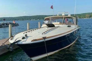 Slide: The Image of 1979 Magnum 38 Sport boat docked on a serene lake with scenic background. - 2
