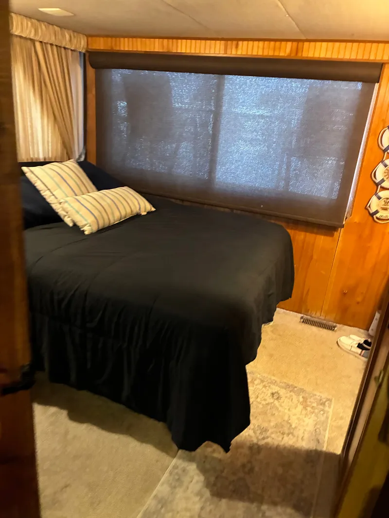 Slide: The Image of Bedroom in a 1993 Gibson 50 boat with black bedding. - 10