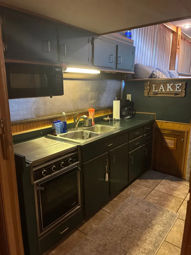 Slide: The Image of Kitchen in a 1993 Gibson 50 boat with stove and sink. - 12