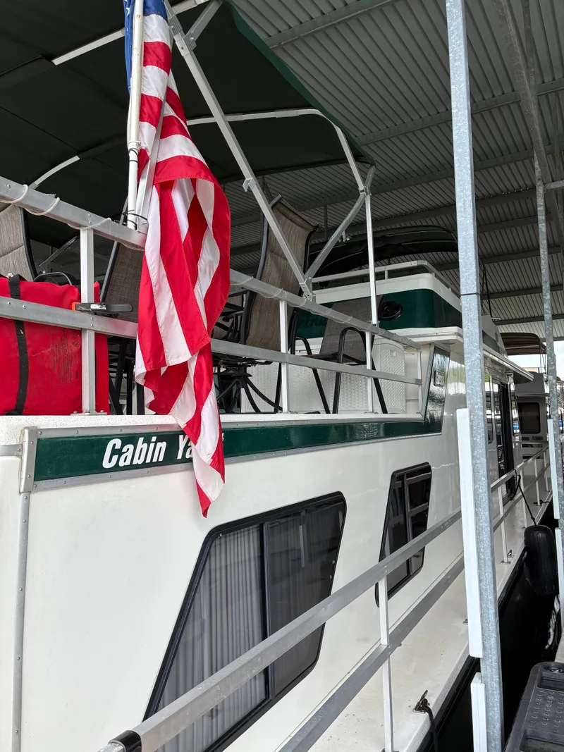 Slide: The Image of 1993 Gibson 50 yacht with American flag docked in marina. - 3