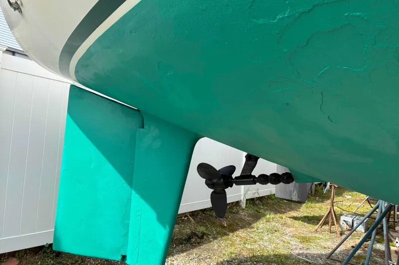 Slide: The Image of 1994 Caliber Cutter Rig sailboat hull and propeller, turquoise color, on land. - 11