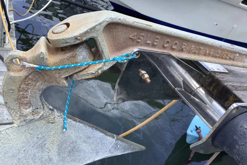 Slide: The Image of Close-up of a boat anchor with rope, attached to a dock. - 12