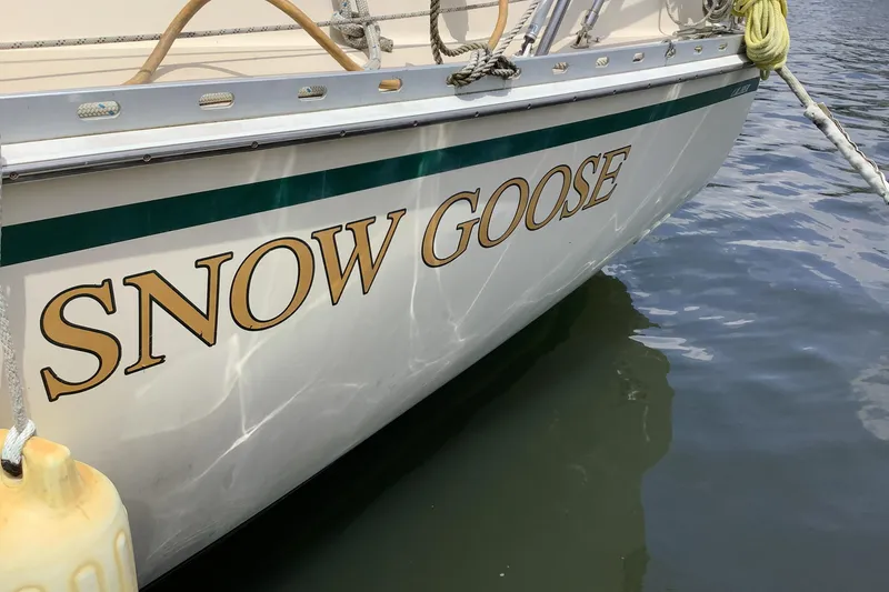 Slide: The Image of 1994 Caliber Cutter Rig sailboat named "Snow Goose" docked on calm water. - 16