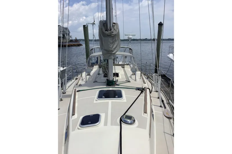 Slide: The Image of A sailboat docked, with visible masts and ropes, under a cloudy sky. - 19